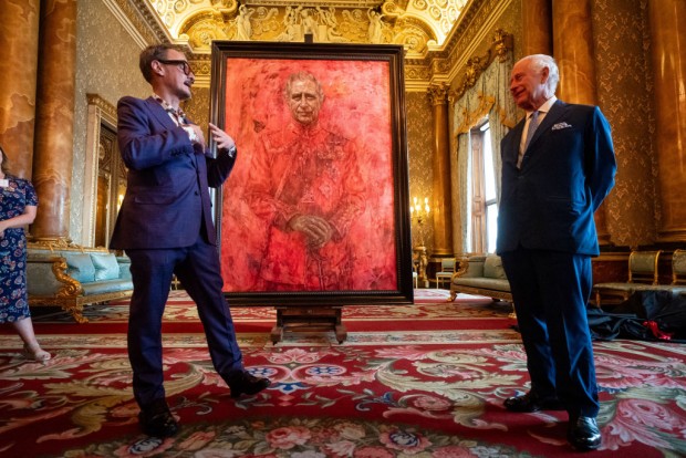 Britain's King Charles III (R) reacts as he stands alongside artist Jonathan Yeo, after unveiling an official portrait of himself wearing the uniform of the Welsh Guards, of which he was made Regimental Colonel in 1975, by artist Yeo, in the Blue Drawing Room at Buckingham Palace in London on May 14, 2024. 