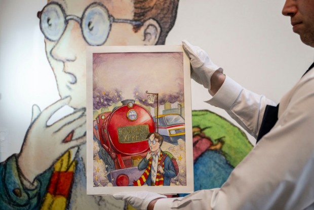 An art handler holds Thomas Taylor's original cover art for J.K. Rowling's 